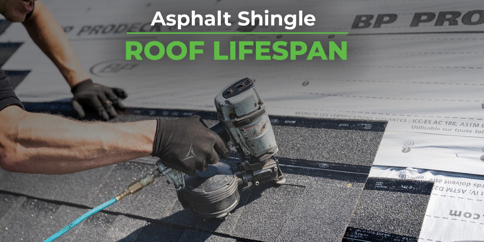 A worker wearing black gloves is using a pneumatic nail gun to install asphalt shingles on a roof, with a roofing underlayment labeled "BP ProDeck" visible in the background.